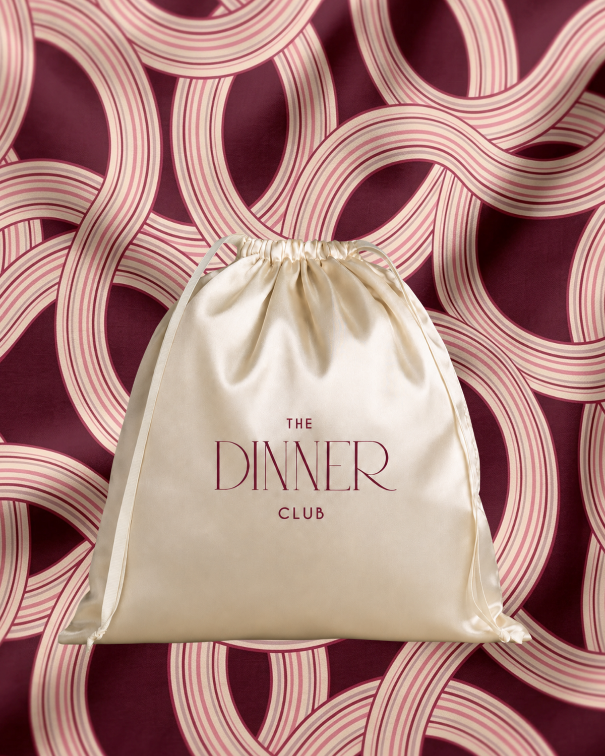 Marea Burgundy fabric swatch — interlocking ribbon bands in burgundy and rose